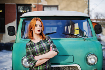 Young red haired girl posed on checkered dress background old re