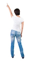 Back view of young brunette woman pointing at wall. beautiful girl. Rear view people collection. backside view of person. Isolated over white background.