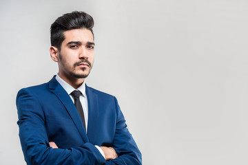 Young attractive man in a blue suit on a gray background. Isolated