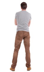 Fototapeta premium Back view of handsome man in shirt and jeanst looking up.