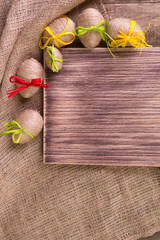 Easter egg in twine near wooden background. Copy space. Frame. Top view. Rustic style.