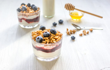 Fitness breakfast with muesli, honey and milk on white table