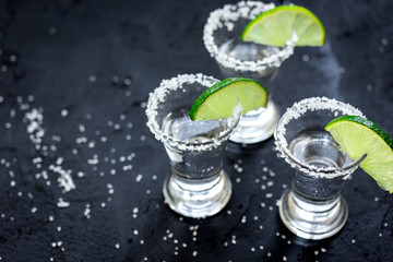 Set for tequila party with lime and salt on black background