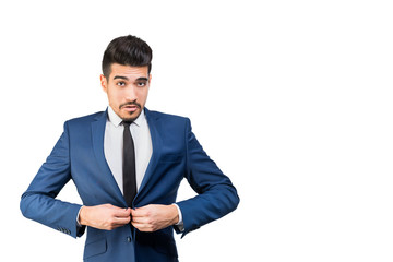 Young attractive man in a blue suit buttoning on a white background. Isolated