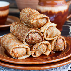 Stuffed pancakes on pottery, selective focus