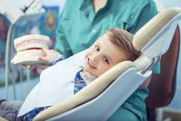 very happy boy after the doctor at the clinic, holding a dental