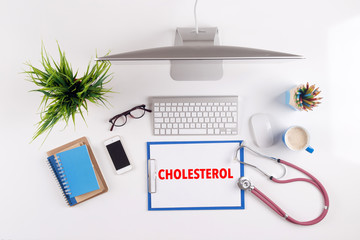Office desk with CHOLESTEROL paperwork and other objects around,