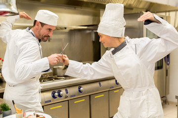 Fototapeta na wymiar funny match in kitchen between chefs