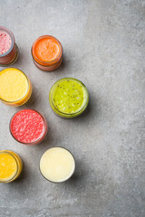 Obraz na płótnie Canvas Glasses of fresh juice on gray stone table. Food background