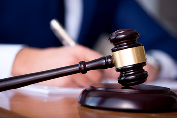 Handsome judge with gavel sitting in courtroom