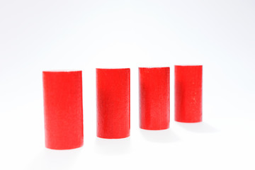 Four red round wooden building blocks in a row one behind the other