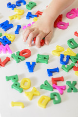 Little girl learning to read using magnetic letters. Learn Study Education School Knowledge Concept