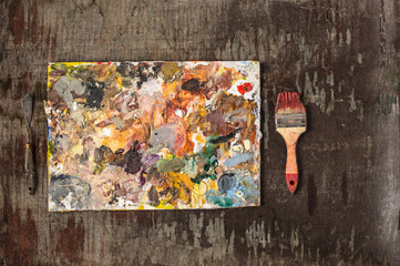 paint brushes and tubes of oil paints on wooden background