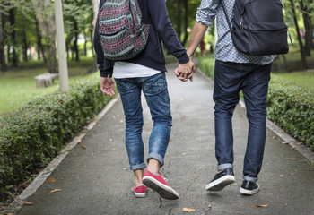 Low section of couple holding hands walking on road - Powered by Adobe