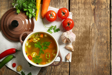 Soup and fresh vegetables on wooden background