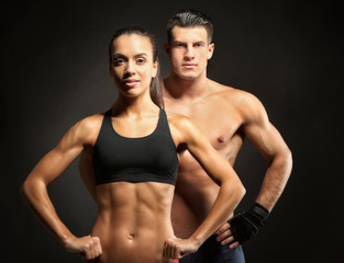 Fototapeta na wymiar Sporty young couple on black background