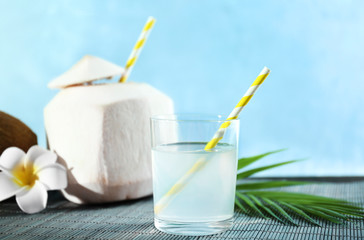 Coconut water in glass and nut on table