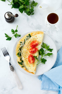 Omelet with spinach, parsley and cheese for breakfast on a light background. Selective focus.