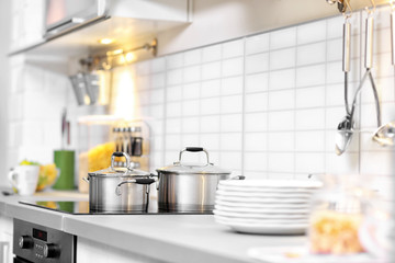 Fototapeta na wymiar Metallic saucepans in modern kitchen interior