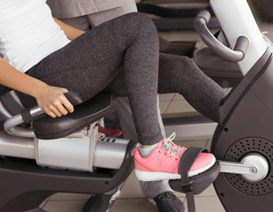 Rehabilitation concept. Young woman doing exercises in gym
