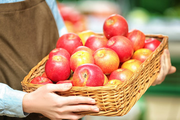 Female hands holding apples in market