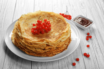 Delicious pancakes decorated with viburnum on plate