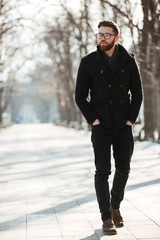 Attractive young man walking in winter park