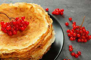 Delicious pancakes decorated with viburnum on plate