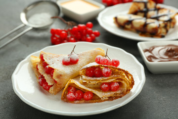 Delicious pancakes with viburnum on plate