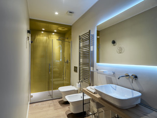 interior view of a modern bathroom with wooden floor in foreground the washbasin countertop and background the masonry shower cubicle
