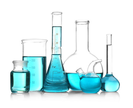 Laboratory glassware with blue samples on white background