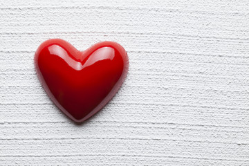 Red heart on white plastered background