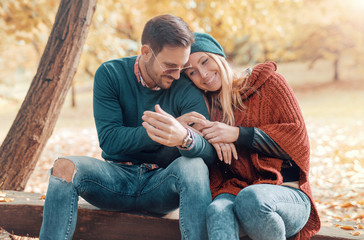 Loving couple sitting on the bench in the autumn park. Love and