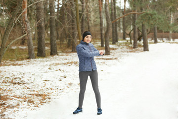 Young woman stretching in winter park