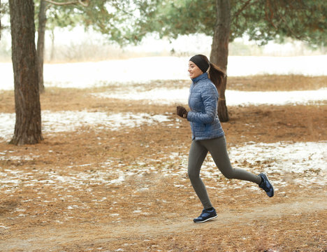 Young woman jogging in winter park