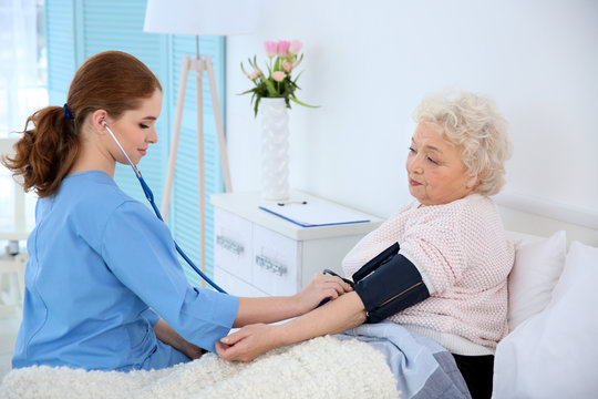 Measuring woman's blood pressure with tonometer