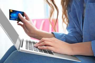 Beautiful young woman doing online shopping at home, closeup