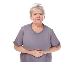 Elderly woman suffering from stomach ache on white background