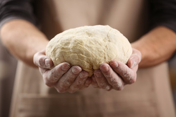 Hands holding dough ready for baking, closeup