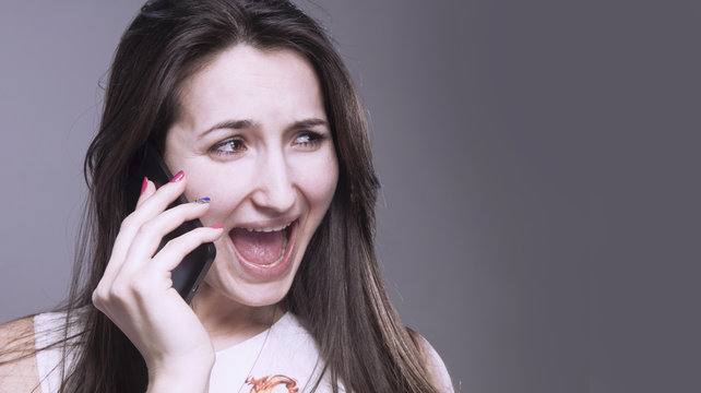 Desperate young woman holding smartphone and shouting