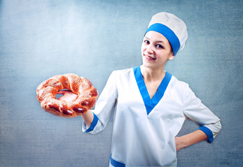 Baker Looking At Freshly Baked Breads In Bakery