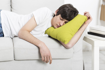 Tired Teenager sleep on the Sofa with the Books