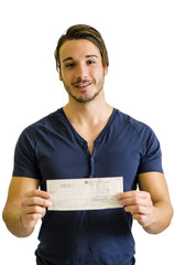 Happy, smiling young man with check or cheque in hands, looking at camera