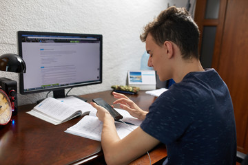 Fototapeta na wymiar Teenager doing homework with computer