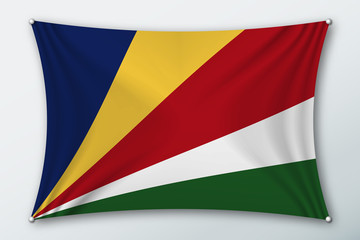 Seychelles islands national flag. Symbol of the country on a stretched fabric with waves attached with pins. Realistic vector illustration.