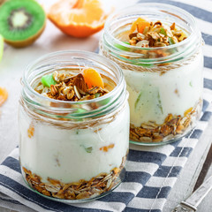 Granola with yogurt and fruits in a rustic jar. Delicious healthy American food for breakfast. Traditional US snack.