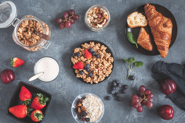 Healthy breakfast with muesli, fruits, berries, nuts on grunge background. Flat lay, top view