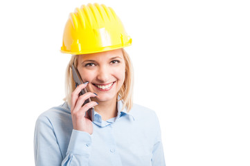 Female engineer wearing helmet talking at phone