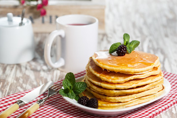 Homemade pancakes with honey and berry fruit. Closeup, selective focus.
