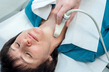 Patientin wird an der Schilddrüse mit Hilfe der Sonographie untersucht